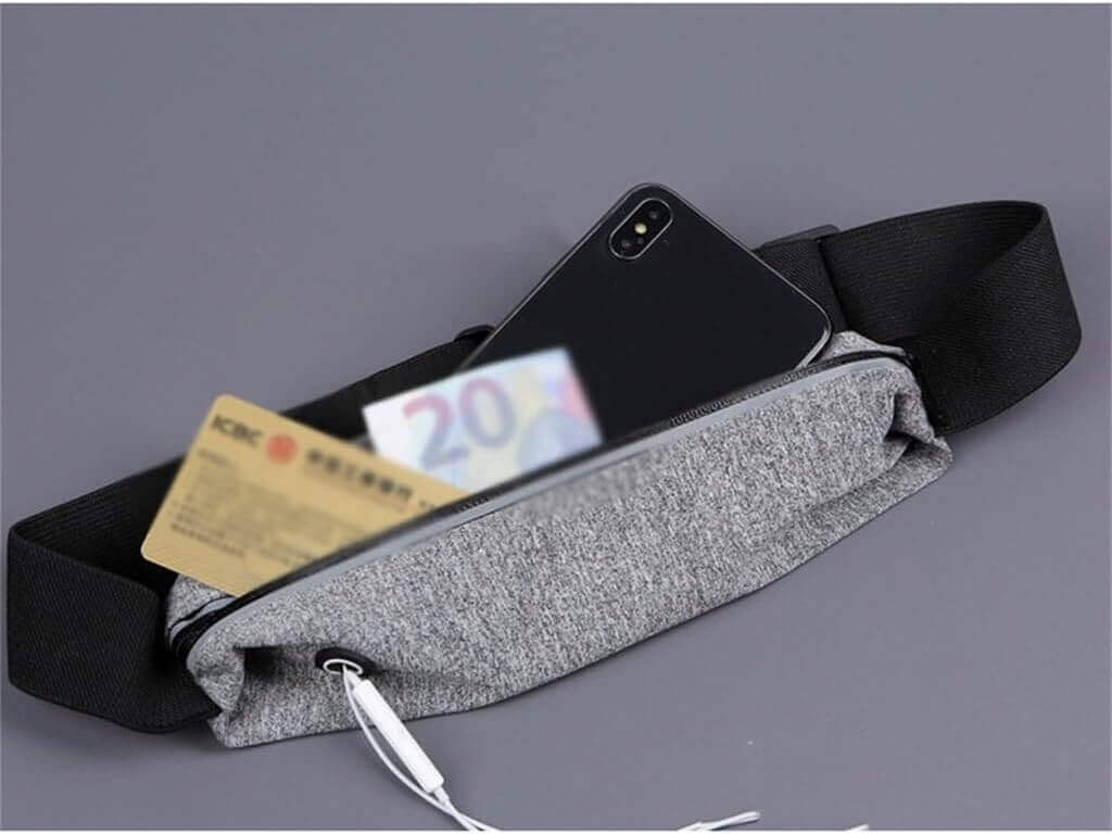 LumiPuro SileäVoima gray waist bag with smartphone and cash inside, ideal for travel and workouts.